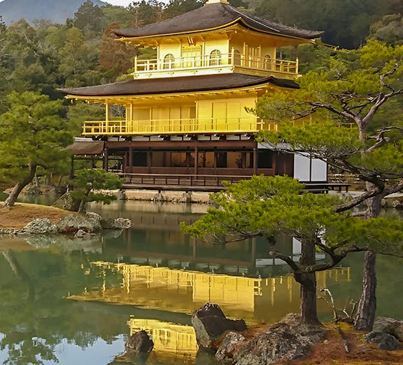 Kinkakuji Temple reflecting in a serene pond surrounded by trees in Kyoto, Japan.