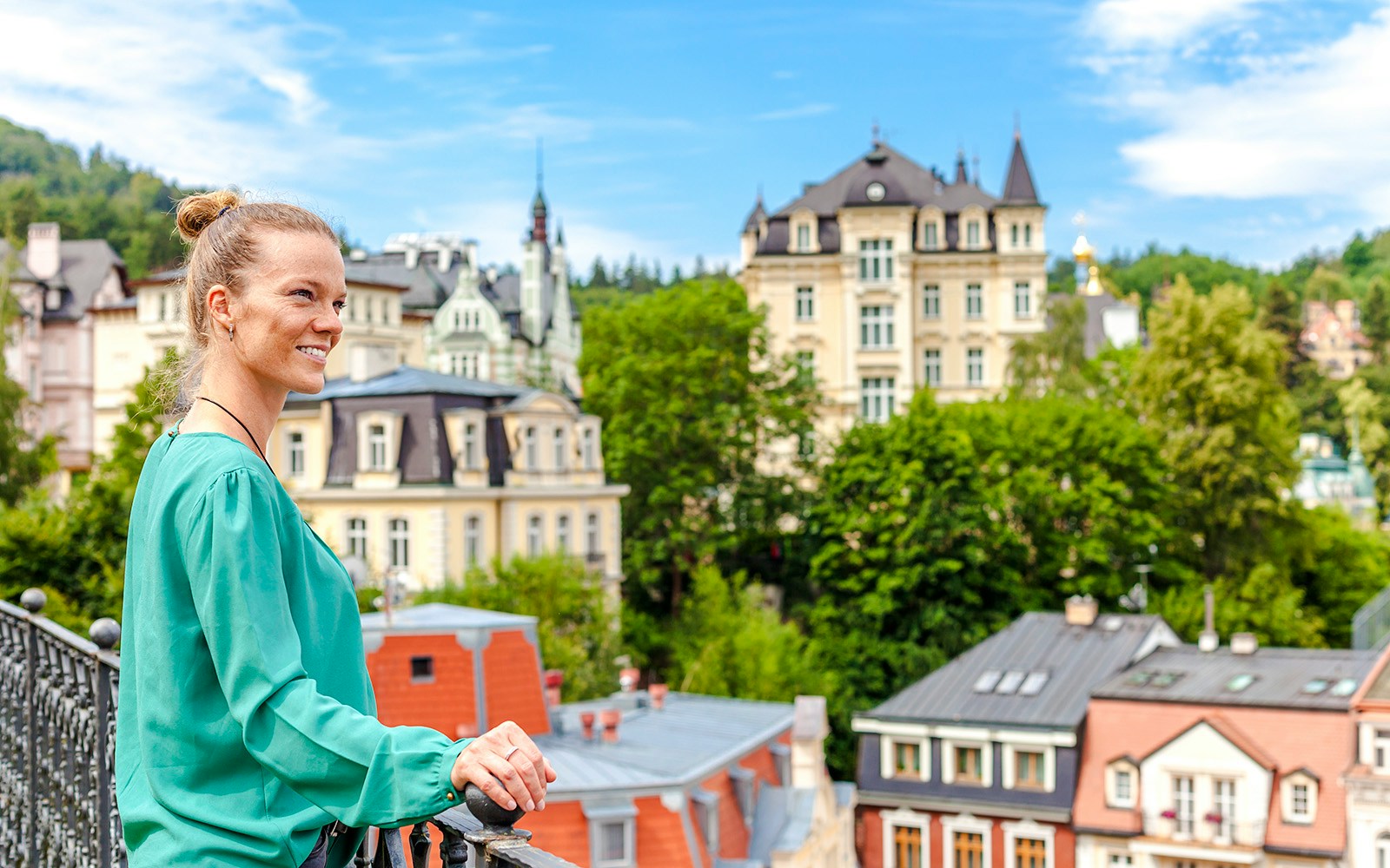 Woman overlooking historic buildings in Karlovy Vary, Czech Republic.