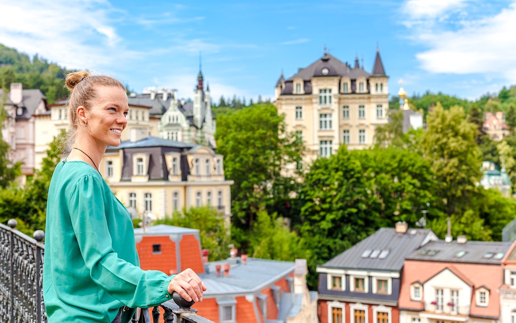 Woman overlooking historic buildings in Karlovy Vary, Czech Republic.