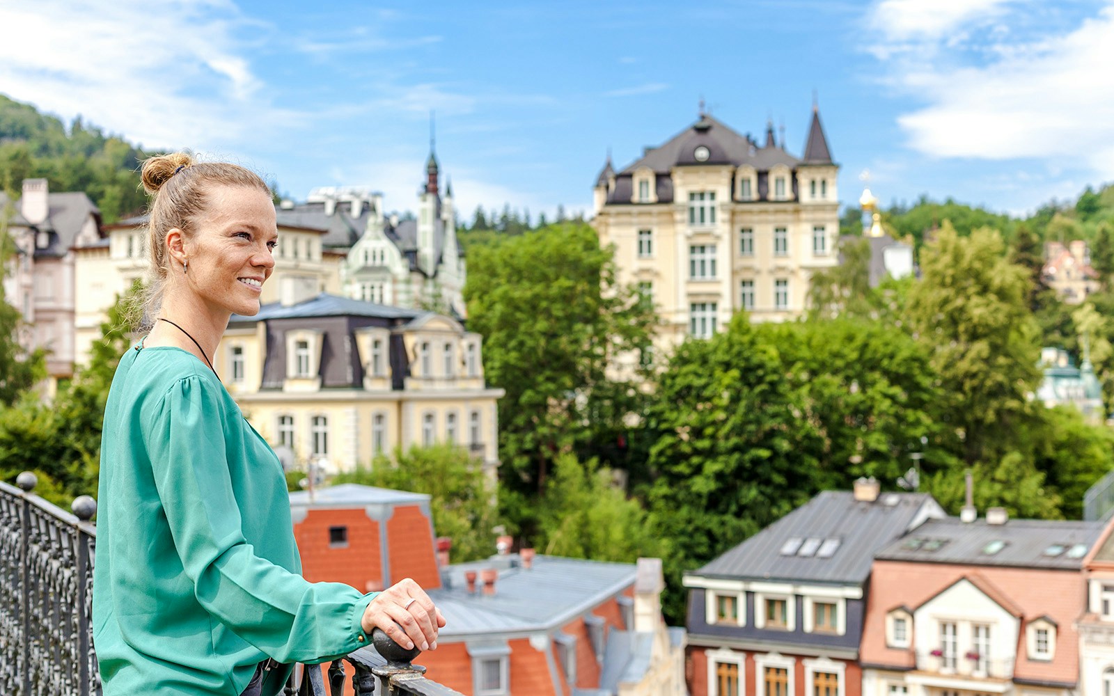 Woman overlooking historic buildings in Karlovy Vary, Czech Republic.