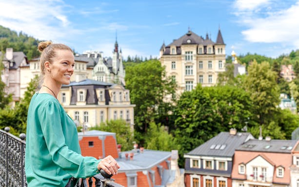 Woman overlooking historic buildings in Karlovy Vary, Czech Republic.