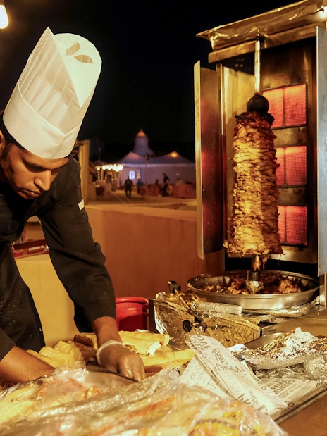 Chef preparing shawarma at a Dubai desert safari event.