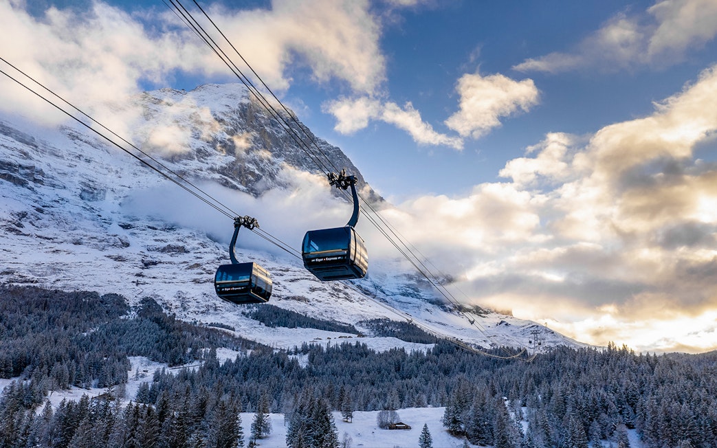 Cable cars ascending snowy mountains from Grindelwald to Jungfraujoch.