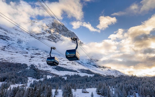 Cable cars ascending snowy mountains from Grindelwald to Jungfraujoch.