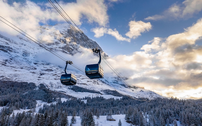 Cable cars ascending snowy mountains from Grindelwald to Jungfraujoch.