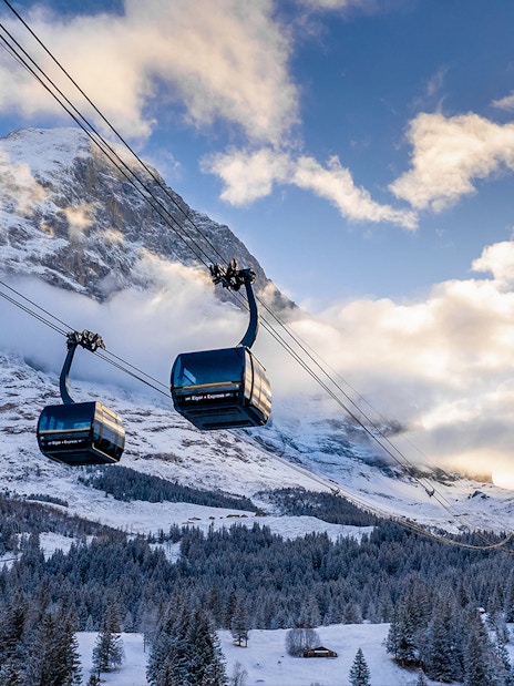 Cable cars ascending snowy mountains from Grindelwald to Jungfraujoch.