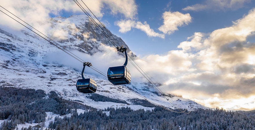 Cable cars ascending snowy mountains from Grindelwald to Jungfraujoch.