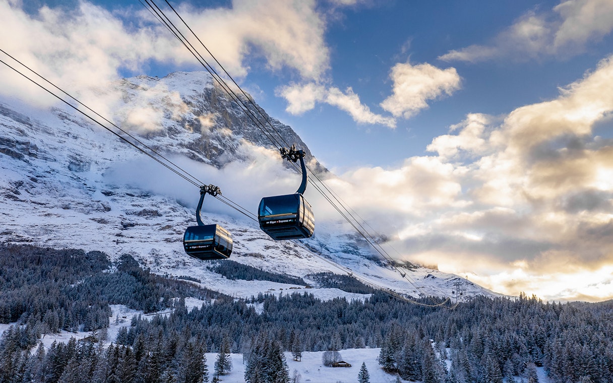 Cable cars ascending snowy mountains from Grindelwald to Jungfraujoch.