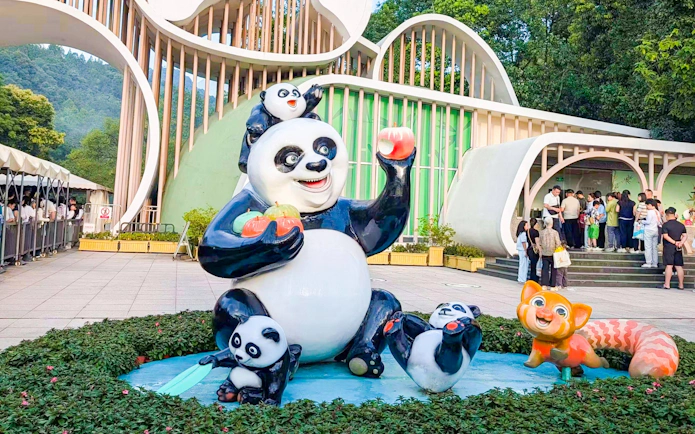 Entrance and panda sculptures at Dujiangyan Panda Valley with visitors in line.