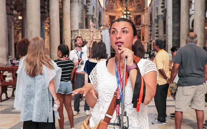 Tour guide explaining Pisa Cathedral interior to visitors.