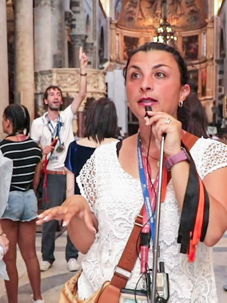Tour guide explaining Pisa Cathedral interior to visitors.