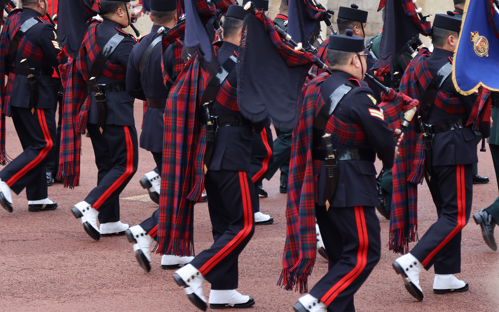 Soldiers in traditional uniforms marching during the changing of the guard at Windsor Castle, England.