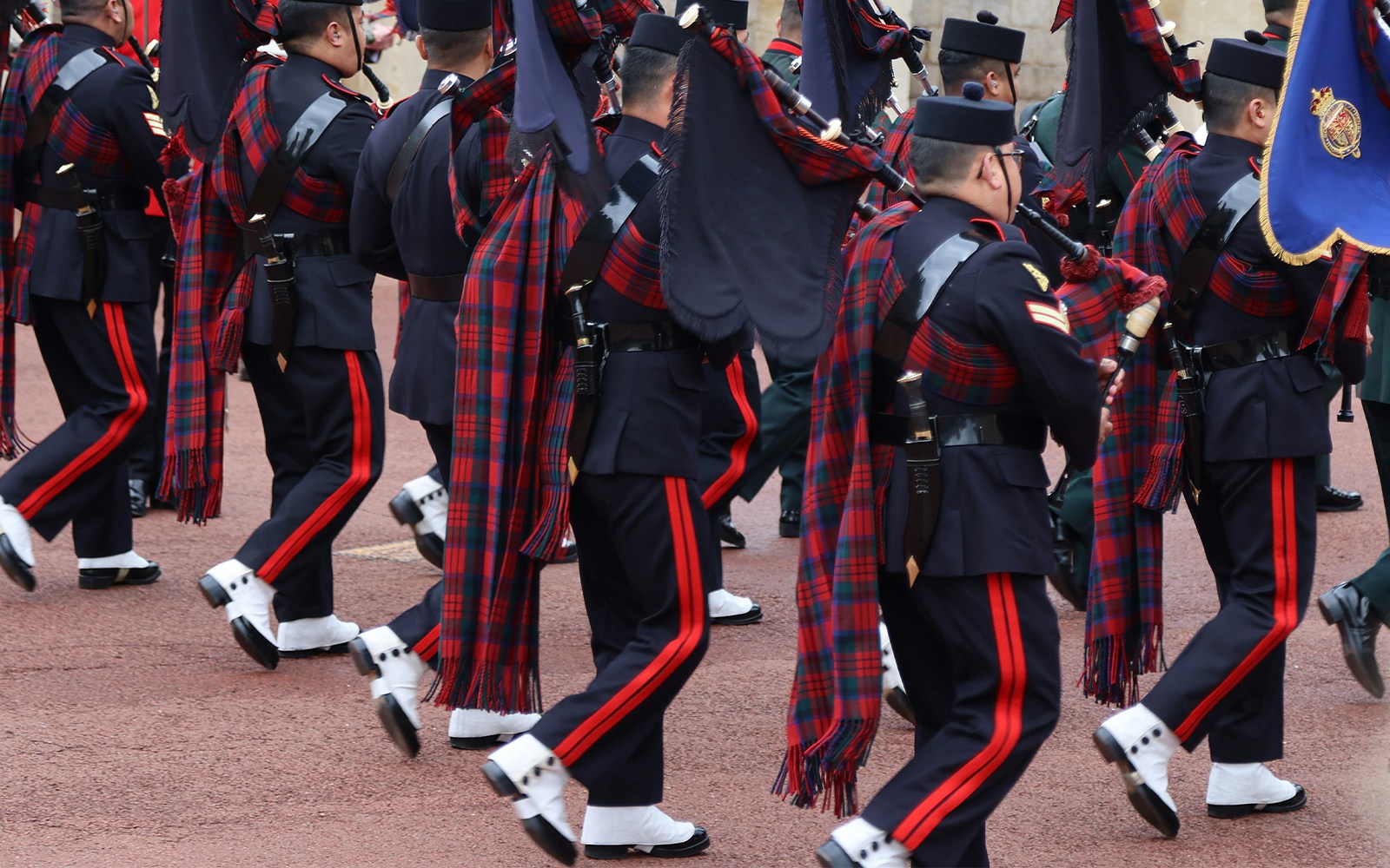 Soldiers in traditional uniforms marching during the changing of the guard at Windsor Castle, England.