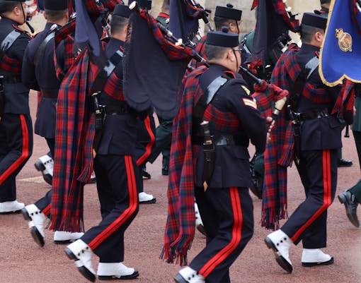 Soldiers in traditional uniforms marching during the changing of the guard at Windsor Castle, England.