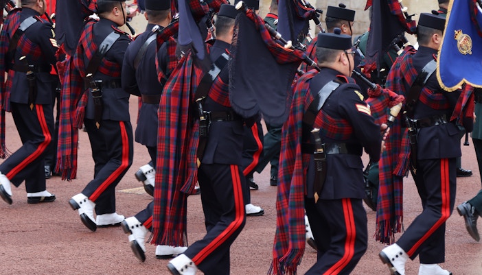 Soldiers in traditional uniforms marching during the changing of the guard at Windsor Castle, England.