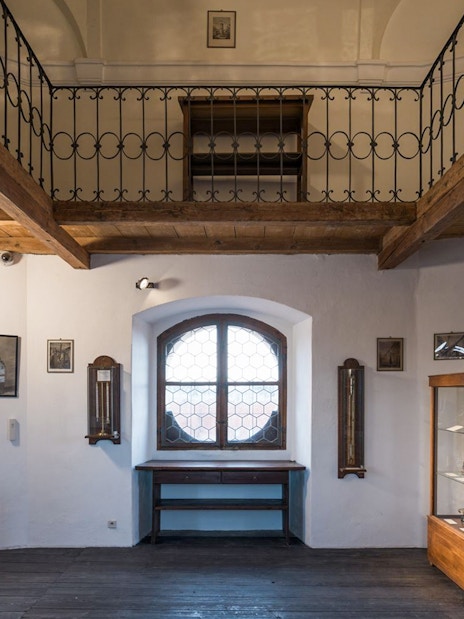 Interior view of the Astronomical Tower of Clementinum, featuring wooden beams and historical displays.