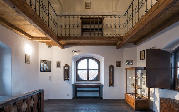 Interior view of the Astronomical Tower of Clementinum, featuring wooden beams and historical displays.