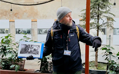 Guide explaining Schindler’s story with historical photos in Krakow's Kazimierz district.