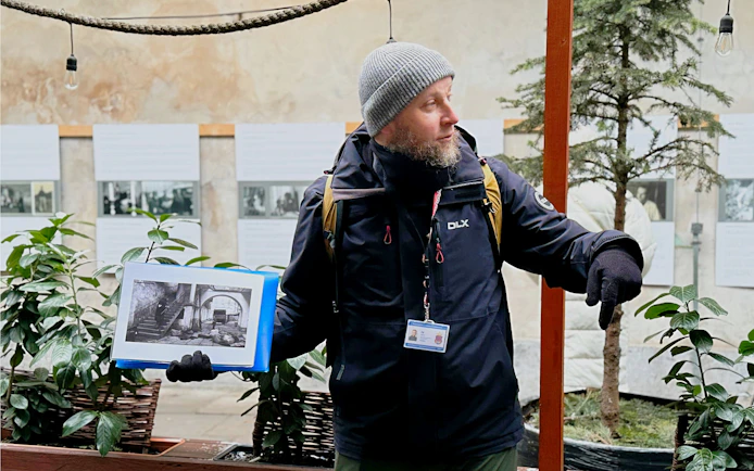 Guide explaining Schindler’s story with historical photos in Krakow's Kazimierz district.