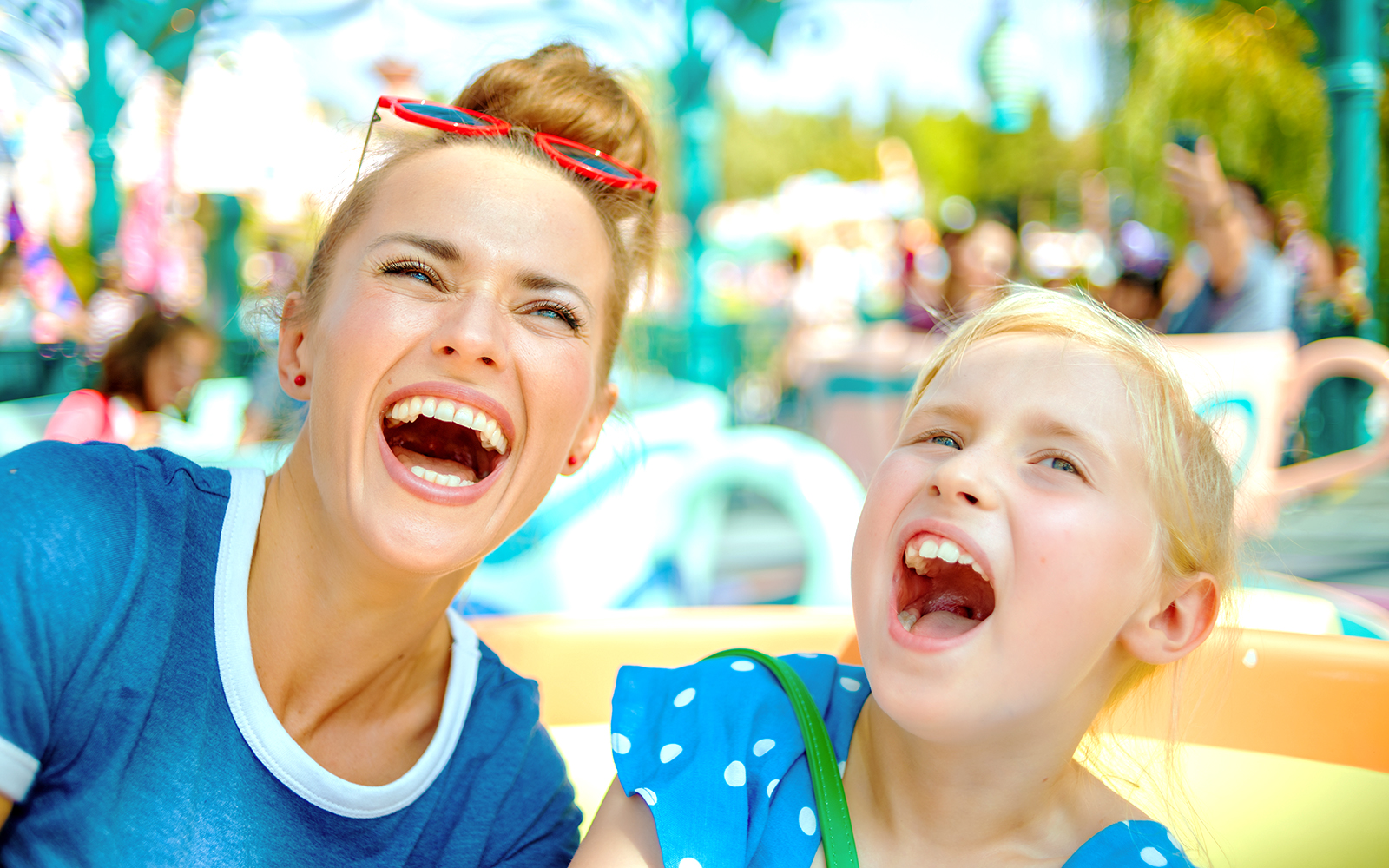 Adults and child enjoying a ride at a theme park.