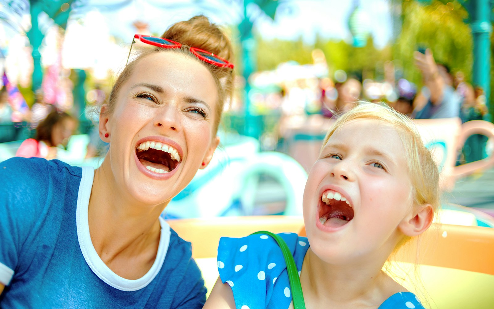 Adults and child enjoying a ride at a theme park.