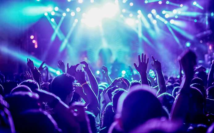 Friends dancing under bright lights at a nightclub.