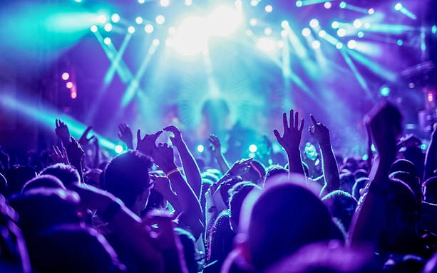 Friends dancing under bright lights at a nightclub.
