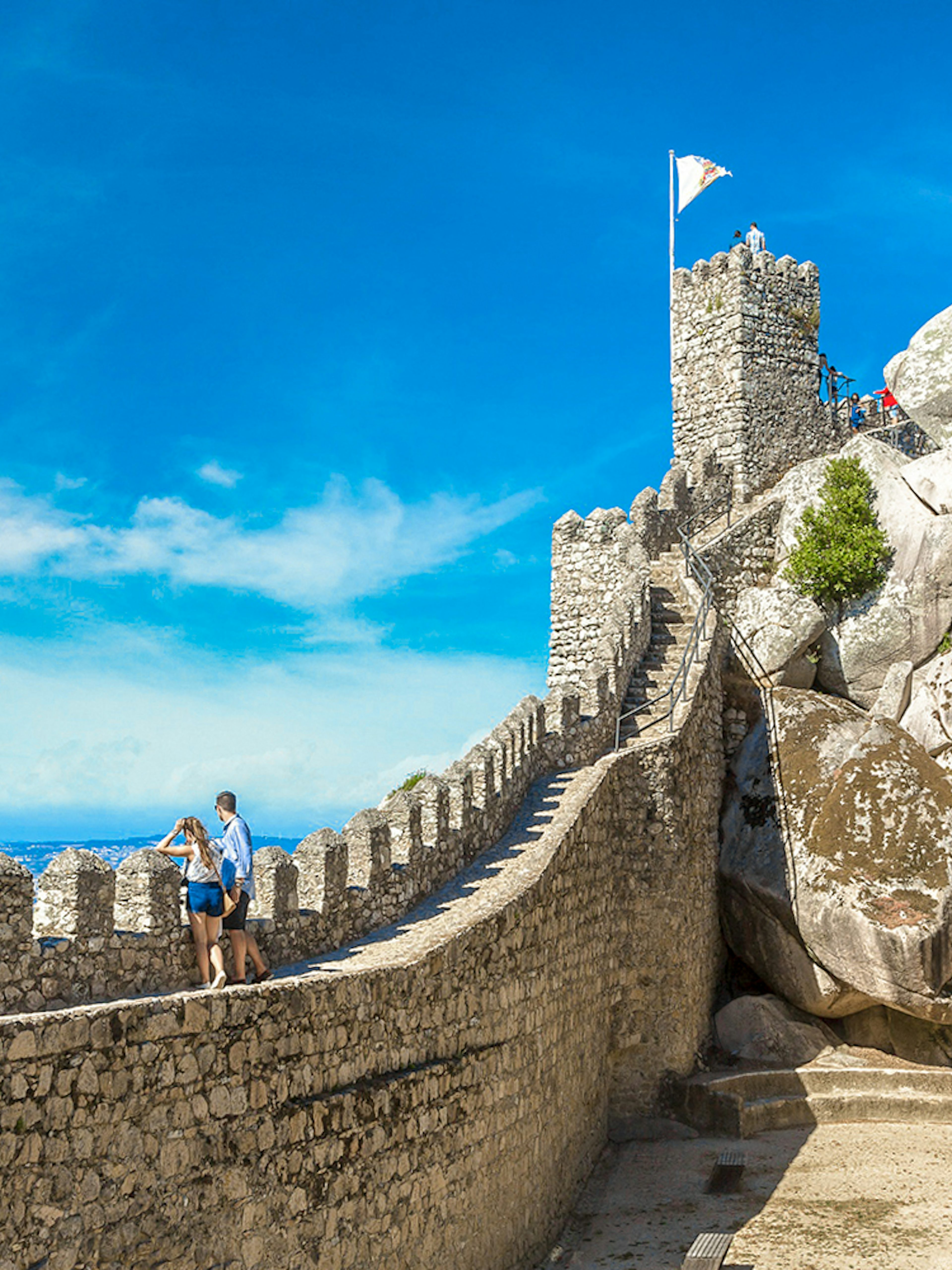 Moorish Castle tower with visitors enjoying panoramic view of Sintra, Portugal.