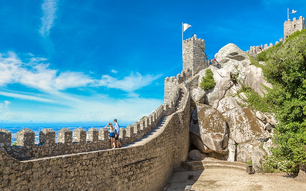 Moorish Castle tower with visitors enjoying panoramic view of Sintra, Portugal.