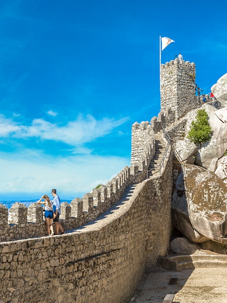 Moorish Castle tower with visitors enjoying panoramic view of Sintra, Portugal.