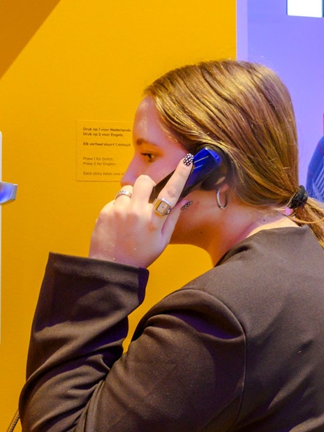 Person using a phone at the Amsterdam in Motion exhibit.