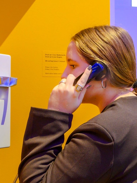 Person using a phone at the Amsterdam in Motion exhibit.
