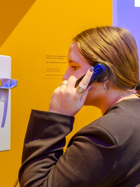 Person using a phone at the Amsterdam in Motion exhibit.