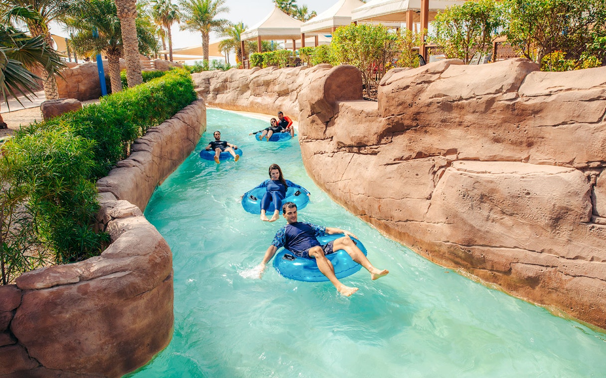 People enjoying a lazy river ride at a water park in Doha.