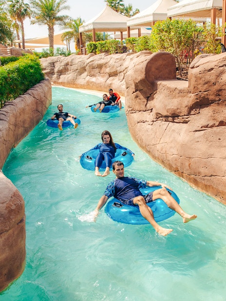 People enjoying a lazy river ride at a water park in Doha.