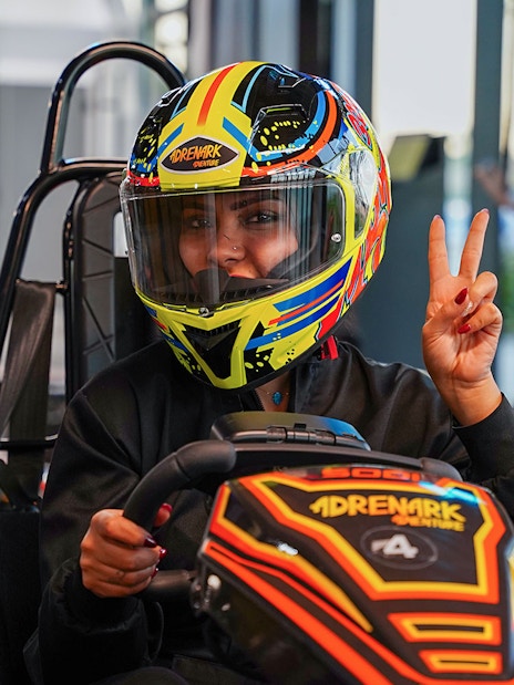 Person in colorful helmet driving a go-kart at Al Qana, Abu Dhabi.
