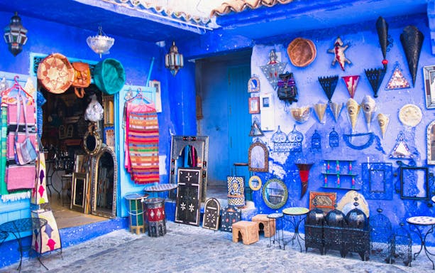 Souvenir shop with colorful textiles and crafts in Chefchaouen, Morocco's blue city.
