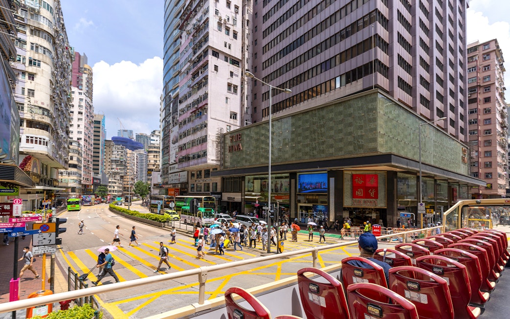 Guests on the Big Bus tour in Hong Kong, viewing city streets and skyscrapers.