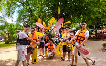 Group of people in life jackets holding paddles before kayaking at Ao Thalane, Krabi.