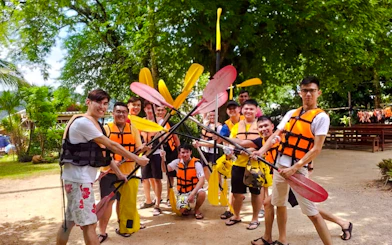 Group of people in life jackets holding paddles before kayaking at Ao Thalane, Krabi.