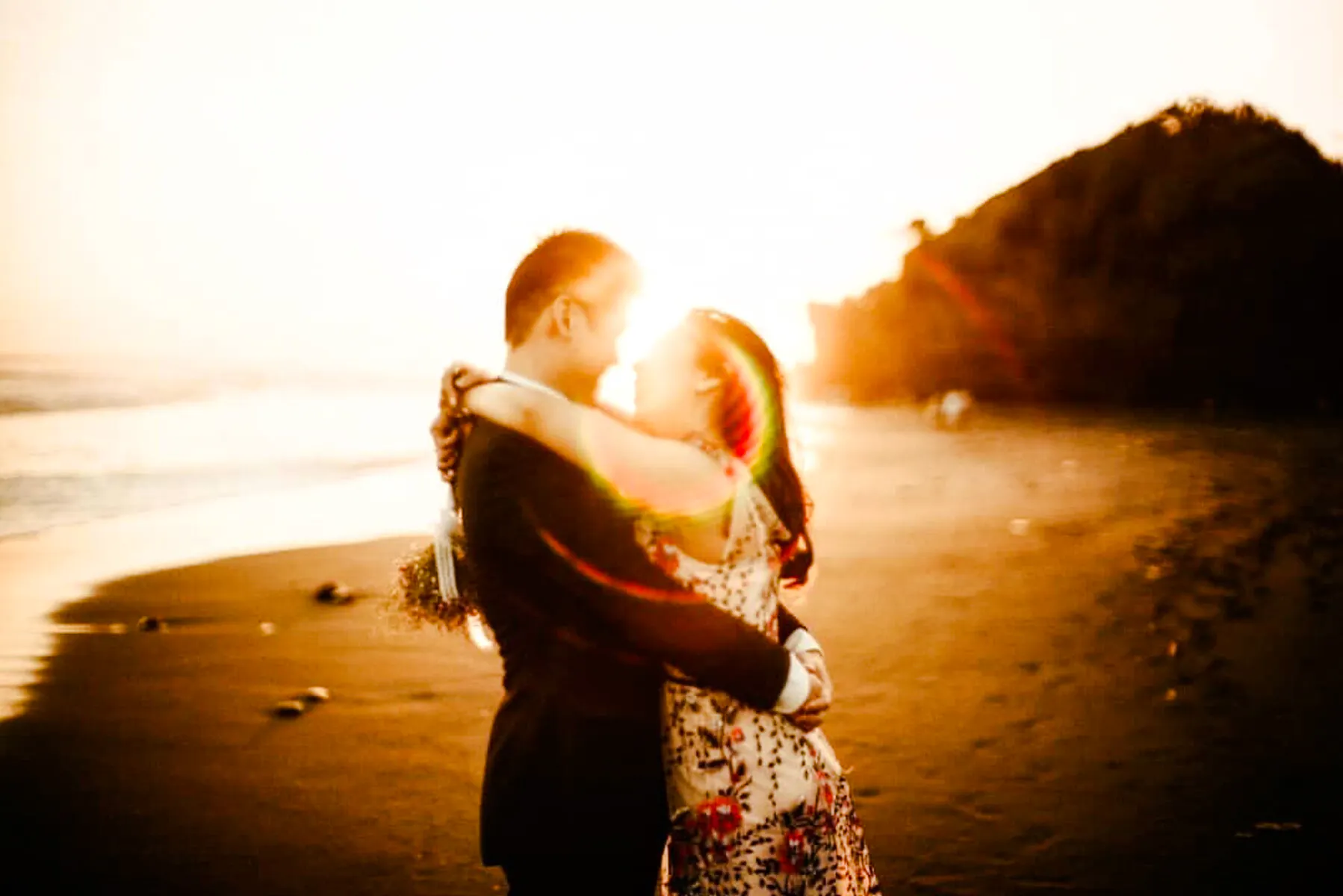 Couple embracing on a Lombok beach at sunset during a professional photoshoot.