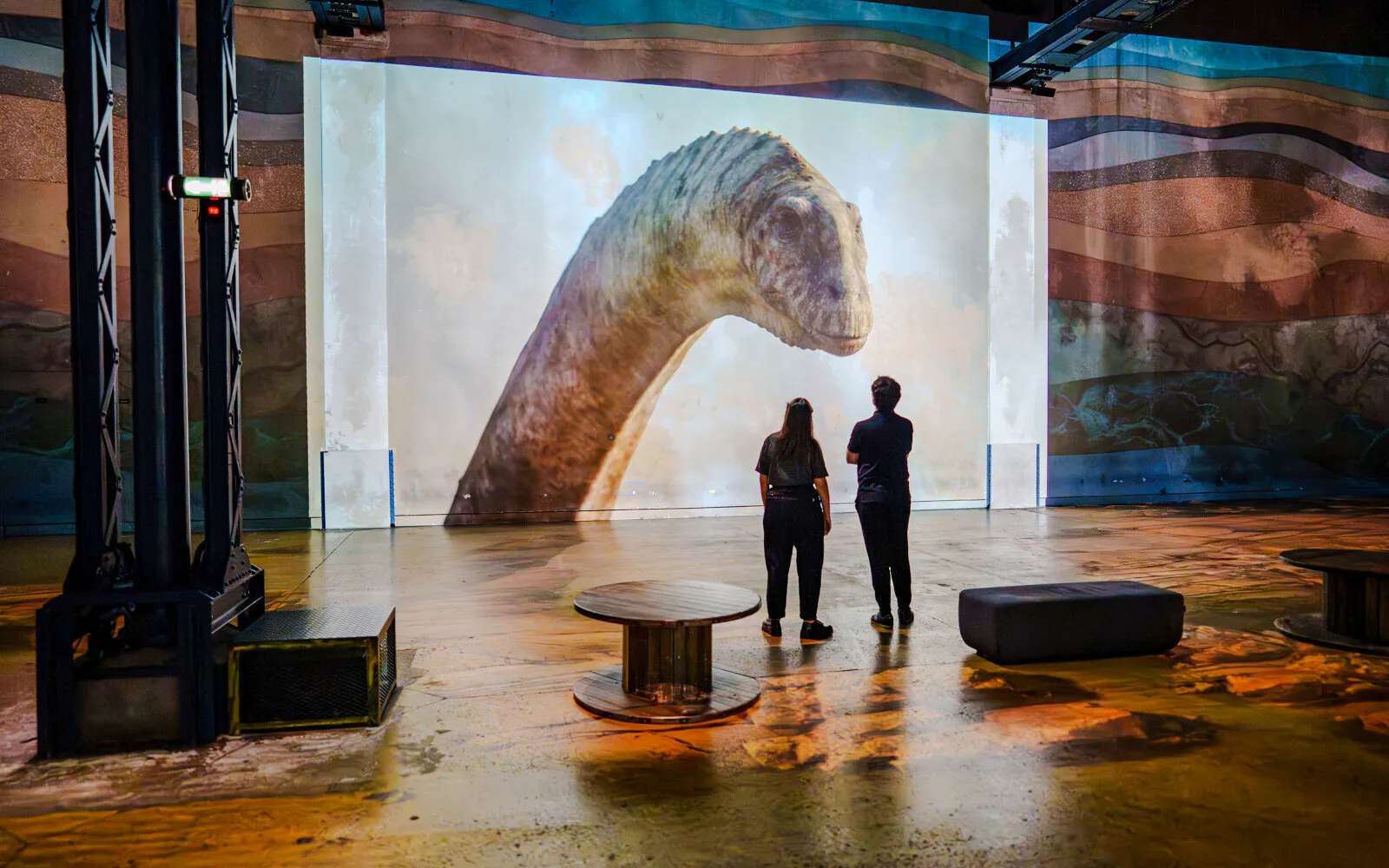 Visitors viewing dinosaur projection at Prehistoric Planet exhibition, Atelier des Lumières.