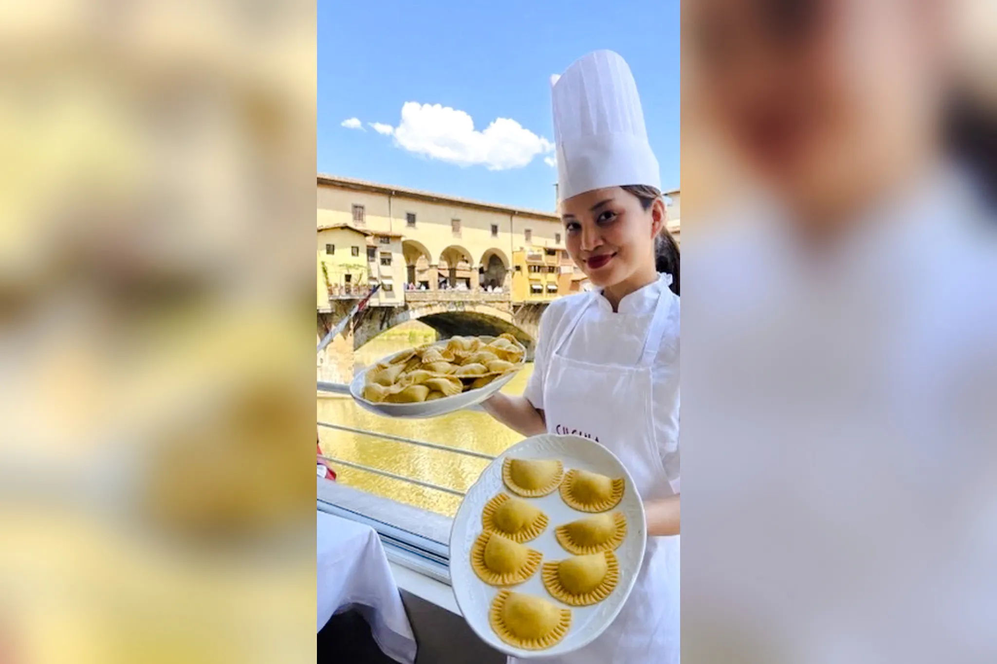 Chef holding plates of pasta with Ponte Vecchio view during Florence pasta class.