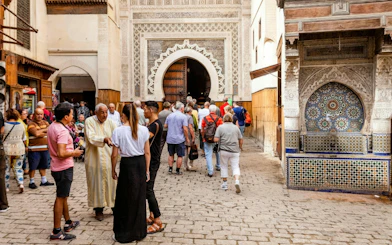 Visitors entering Al Attarine Madrasa in Fes Medina, Morocco.