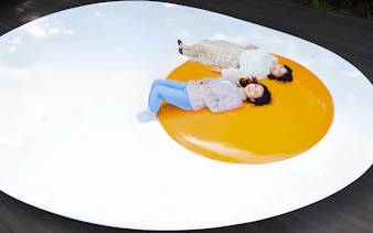 Visitors lying on a large egg sculpture at The Hakone Open-Air Museum.