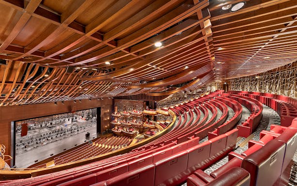 Dubai Opera interior with red seating and stage view.