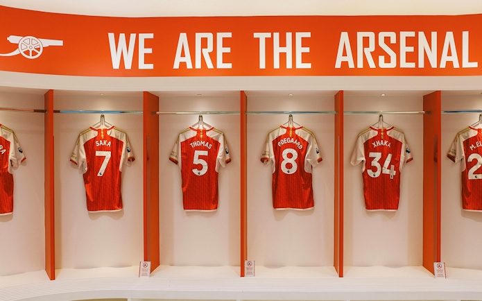 Arsenal FC jerseys displayed in the Emirates Stadium locker room.