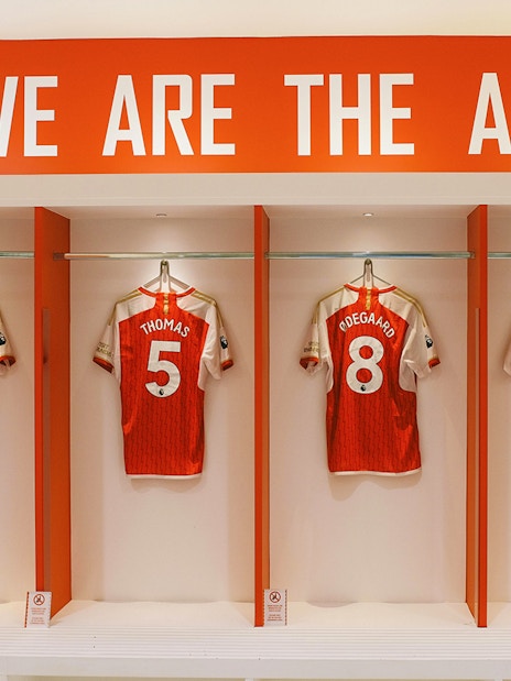 Arsenal FC jerseys displayed in Emirates Stadium locker room, London.
