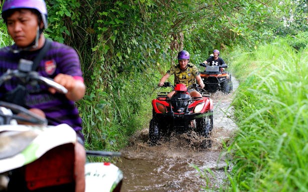 Quad biking through muddy tracks in Bali jungle.