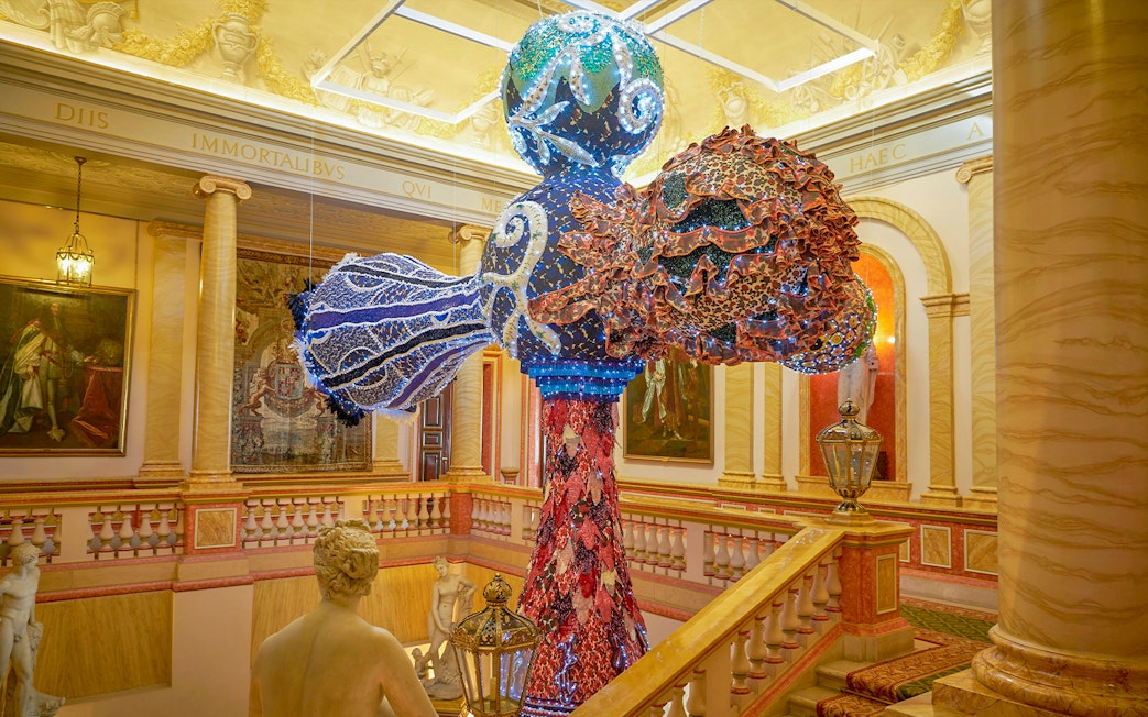 Colorful sculpture in Liria Palace interior, Madrid, with classical statues and ornate decor.
